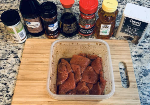 Beef slices coated in marinade in a plastic container