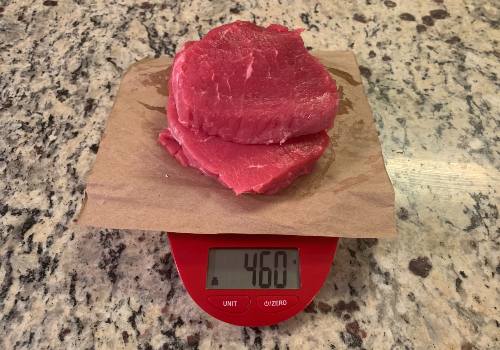 Raw beef on a digital scale reading 460 grams