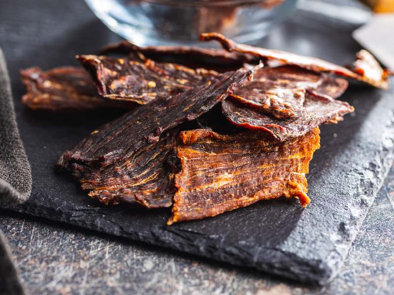 Dried beef slices on a black serving board