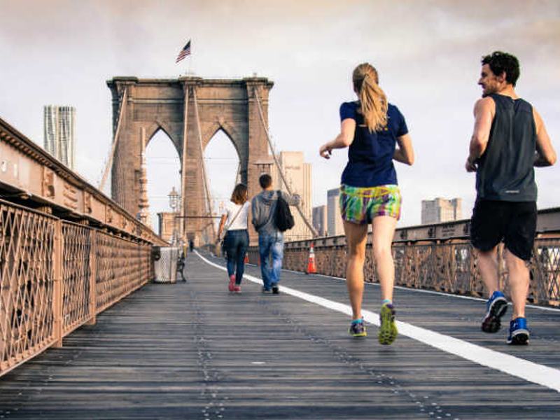 Runners crossing a pedestrian bridge