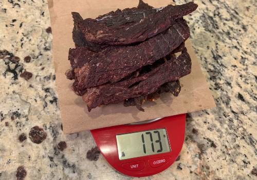 Homemade jerky on a scale reading 173 grams