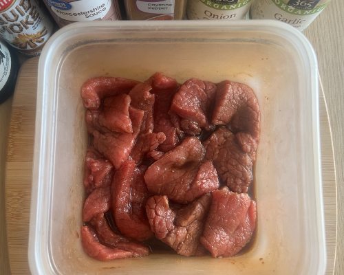 Beef pieces in a rectangular container of marinade