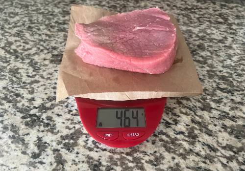 Raw beef on a scale reading 464 grams
