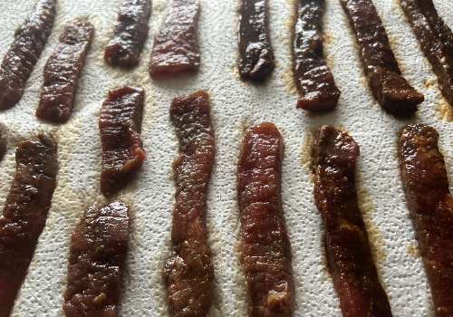 Marinated Cajun beef strips laid out on paper towels