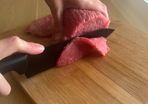 A cook slicing eye of round into long strips