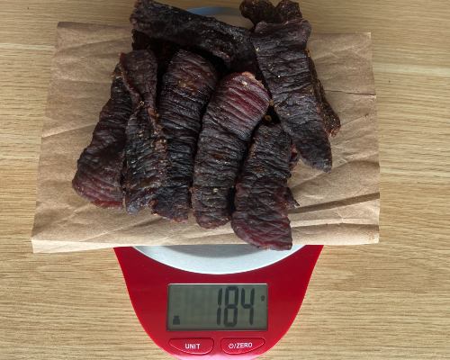 Finished spicy jerky on a scale reading 184 grams