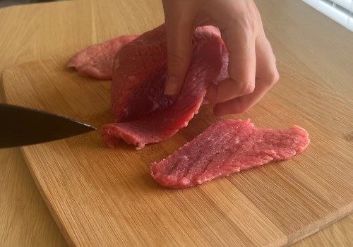 A beef roast being cut into thin slices