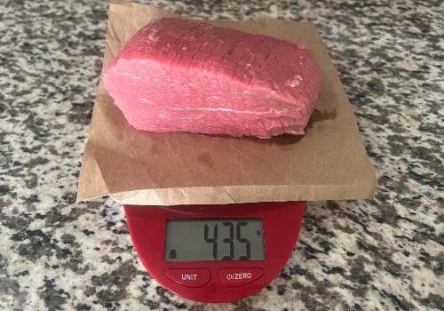 Raw beef on a scale reading 435 grams