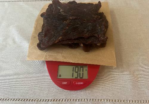 Barbecue beef jerky on a scale reading 190 grams