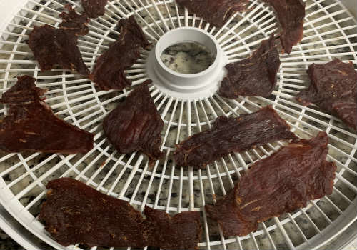 Dried Duke's-style jerky pieces on a round tray