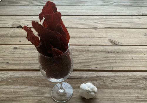 Long homemade jerky pieces standing in a stemmed glass