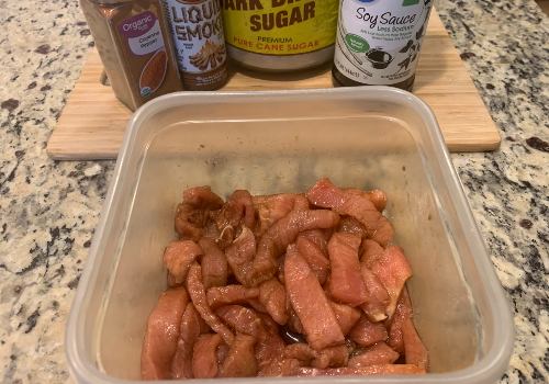 Pork strips coated in marinade in a rectangular container