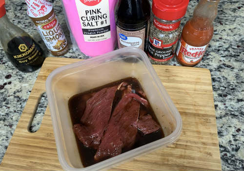 Wide beef slices in a container of dark marinade