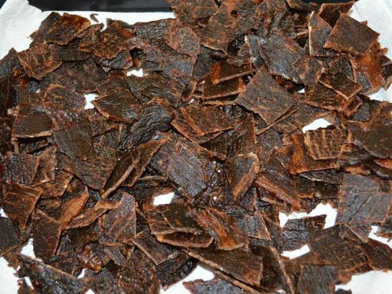 Many small dried jerky pieces spread over a white surface