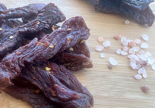 Beef jerky beside a small pile of coarse salt