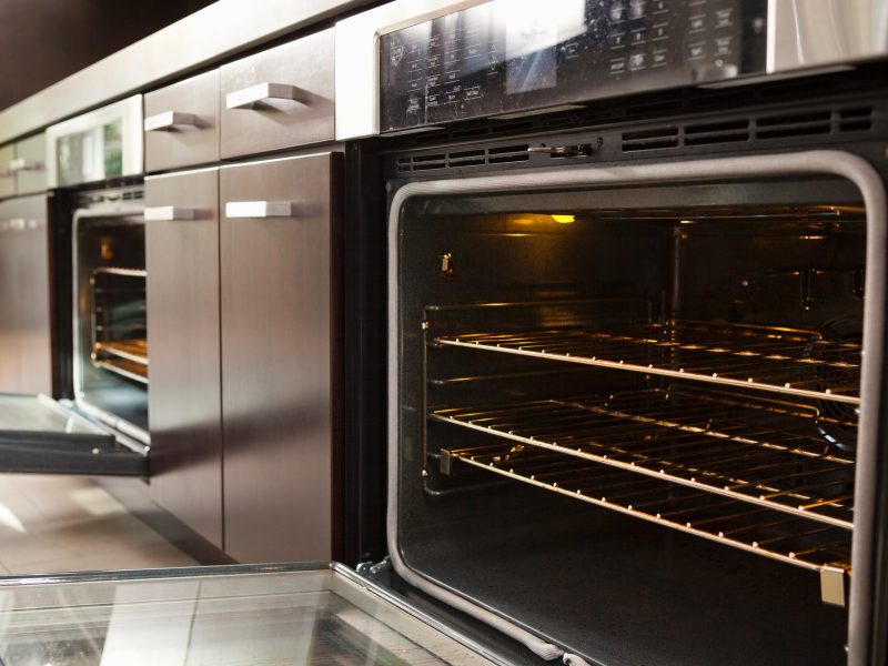 An open kitchen oven with empty wire racks