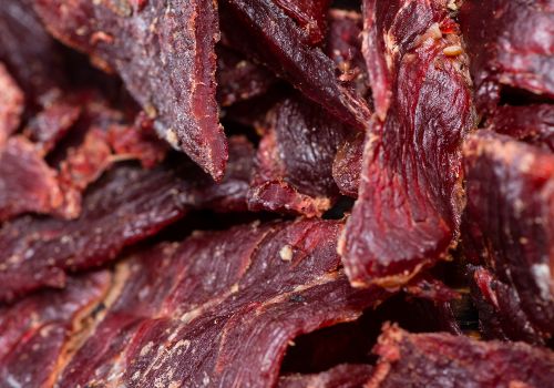 A pile of long, dark-red jerky strips