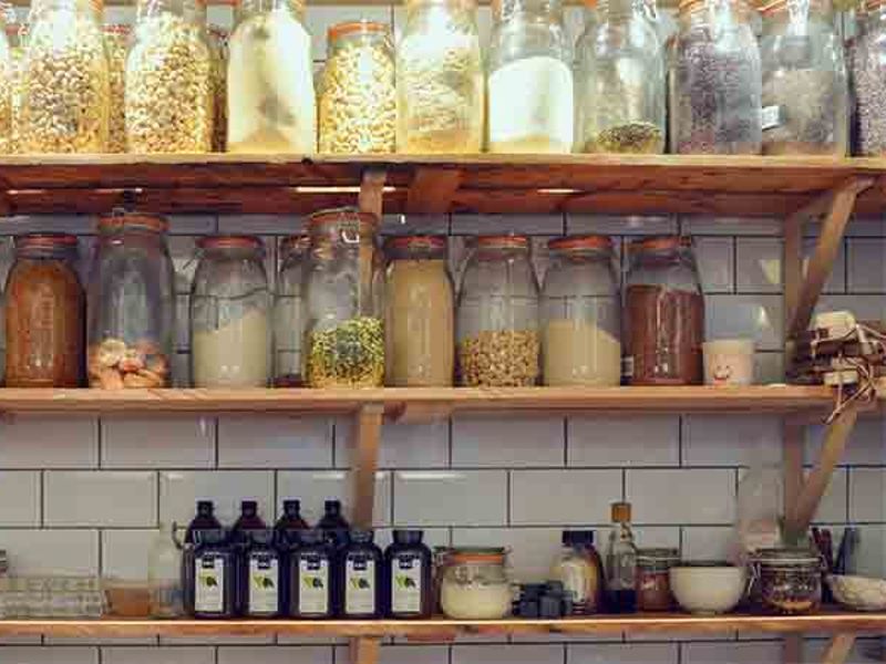 Kitchen shelves lined with glass jars of dry ingredients