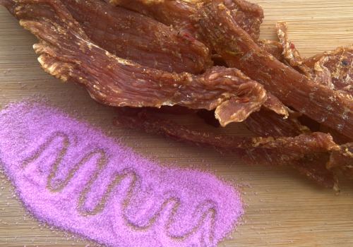 Dried jerky beside a mound of bright pink salt