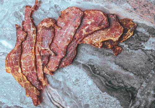Slices of cured meat spread on parchment