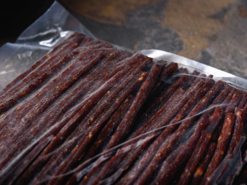 Long dried meat sticks sealed in a clear vacuum bag