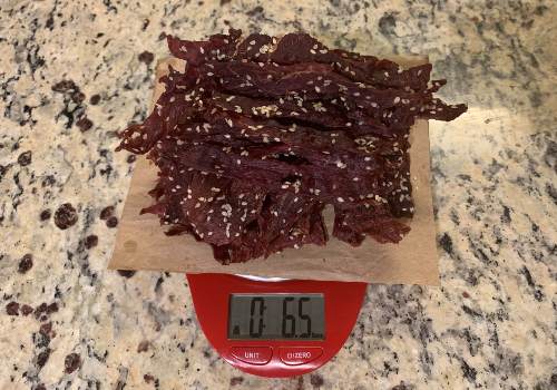 Finished sesame jerky weighed in ounces on a red scale