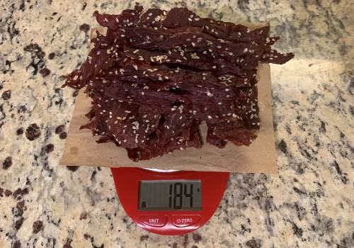 Finished sesame jerky on a scale reading 184 grams