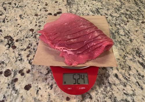 The raw beef slices weighed with the scale set to grams