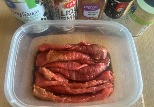 Beef strips in a container of marinade