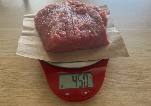 Raw beef on a scale reading 450 grams