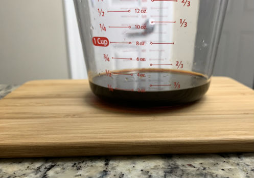 Dark sauce measured in a clear cup