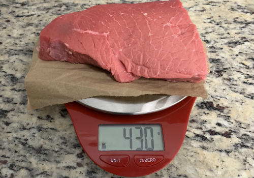 Raw beef on a scale reading 430 grams