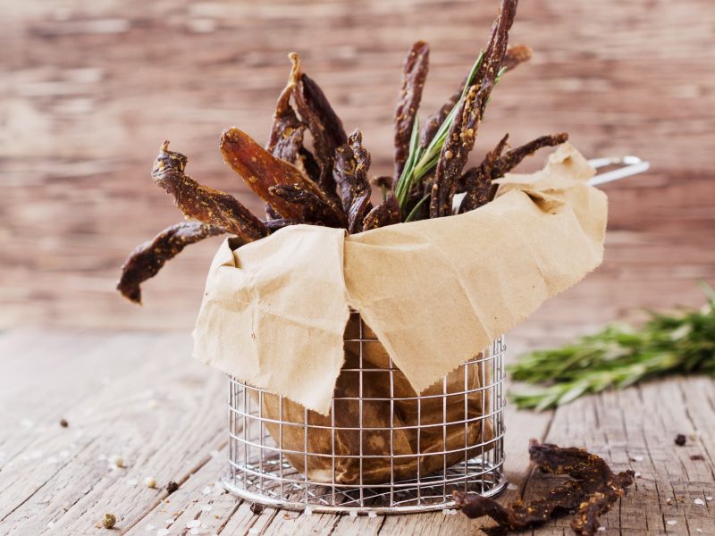 Long jerky strips standing in a paper-lined wire basket