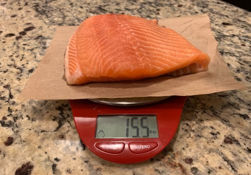 The salmon fillet weighed in ounces on a red scale