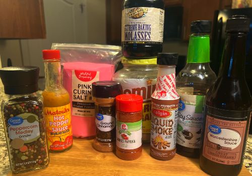 Liquid smoke, brown sugar, sauces, and seasonings on a board