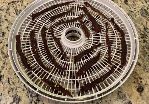 Dried jalapeno jerky strips on a white dehydrator tray