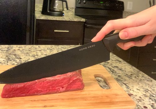 A knife slicing a firm piece of beef on a board