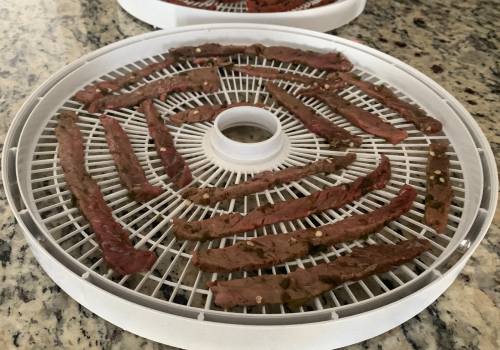 Jalapeno-marinated beef strips on a round dehydrator tray