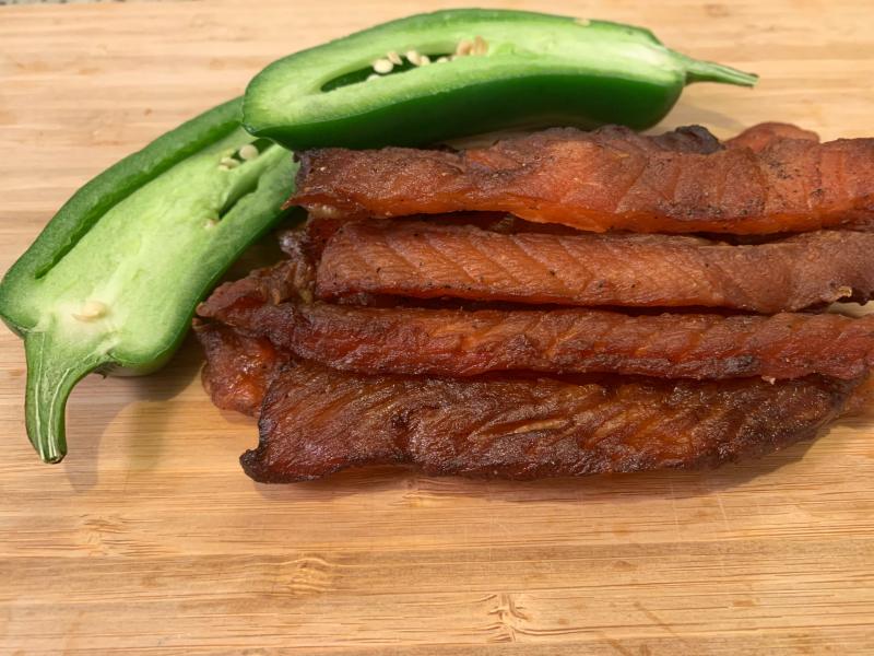 Salmon jerky strips beside halved green peppers