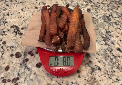 Finished salmon jerky on a scale reading 8.0 ounces