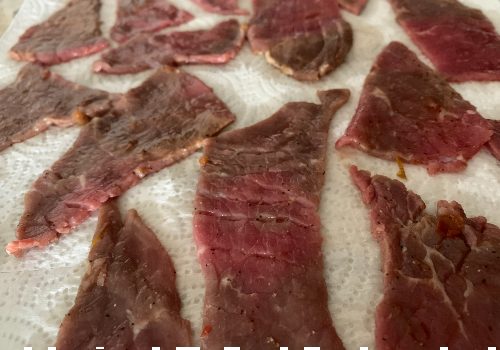 Marinated beef pieces draining on paper towels