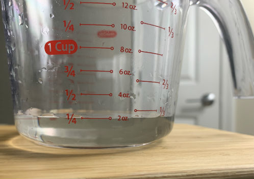 Small amount of clear liquid in a glass measuring cup