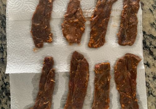 Marinated beef strips draining on paper towels