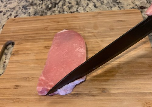 Knife trimming the fat from a pork chop