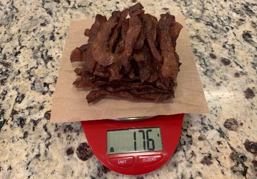Finished pork jerky on a scale reading 176 grams