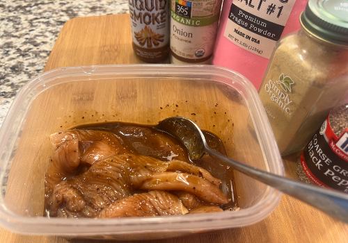 Turkey strips in teriyaki marinade inside a plastic container
