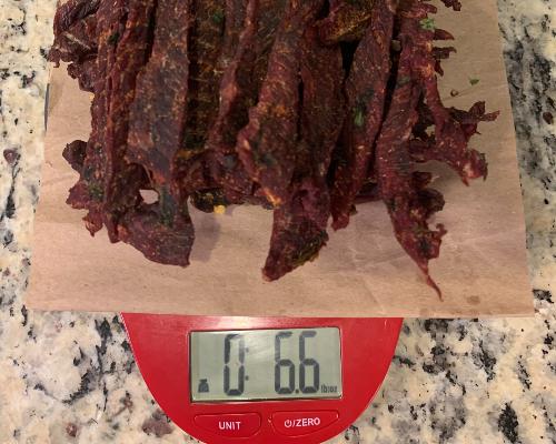 Finished beef jerky on a scale reading 6.6 ounces