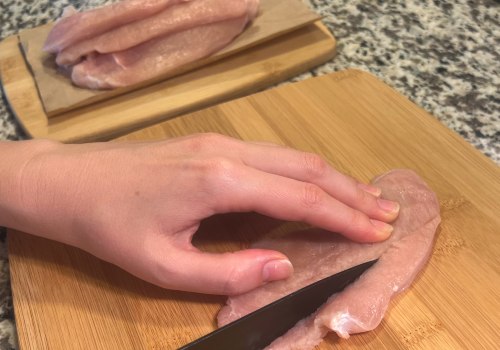 Hands slicing a turkey cutlet into strips