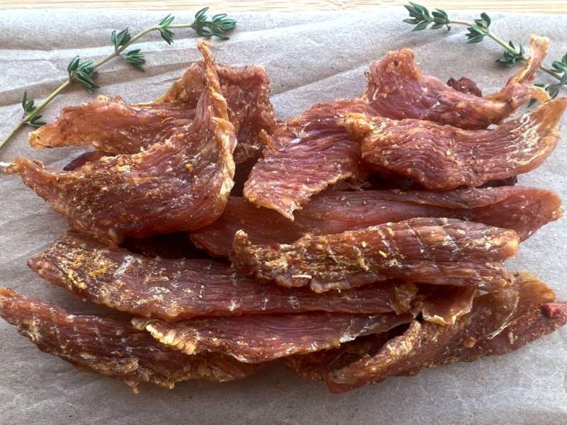 Seasoned turkey jerky piled on parchment paper