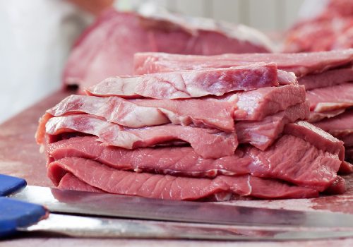 Stack of thin raw meat slices on a board